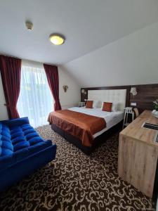 a hotel room with a bed and a couch at Penzión Pulse in Podhájska