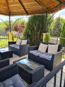 a patio with wicker couches and a glass table at Penzión Pulse in Podhájska