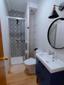 ein Badezimmer mit Toilette, Waschbecken und Spiegel in der Unterkunft Piso cerca Playa con 2 duchas y 5 Aires Acondicionados in Almería + 12 Fotos