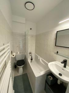 a white bathroom with a toilet and a sink at Taïcyté Beg Meil in Fouesnant