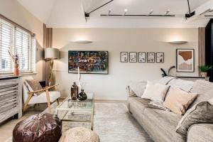 a living room with a couch and a glass table at Walk to Marlowe Theatre from our lovely flat in the city centre in Canterbury