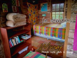 1 dormitorio con cama y estante para libros en MUNAY, Posada rural para el sosiego en Alcalá