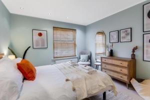 a bedroom with a large bed and a wooden dresser at Walk to Marlowe Theatre from our lovely flat in the city centre in Canterbury