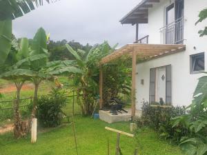 a garden outside a house with a wooden pergola at Apartamento los 3B in Manabao