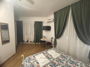 ジェノヴァにあるB&B Cavour16のベッドルーム1室(緑のカーテンとテーブル付きのベッド1台付)