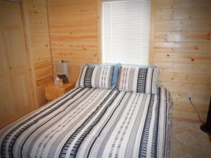 a bed in a wooden room with a window at Lucky Guesthouse in Trapper Creek