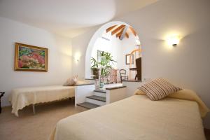 a bedroom with a bed and a mirror and a table at Hostal Los Pinos in Cala de Sant Vicenc