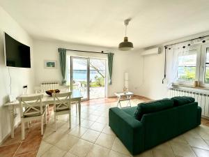a living room with a green couch and a table at Rosmarin Apartments Sea View Garden Side in Jadranovo +25 photos