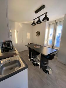 a kitchen with a black table and a sink at Taïcyté Beg Meil in Fouesnant