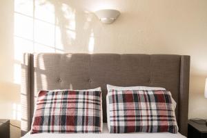a bed with two plaid pillows on top of it at One bedroom one bath apartment in Hollywood in Los Angeles