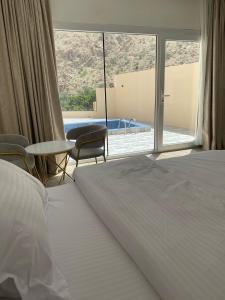 Dawwah的住宿－إستراحة وادي بني خالد，一间卧室设有一张床和一个大窗户
