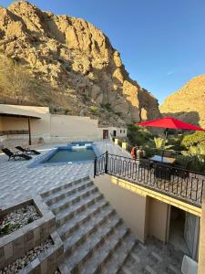 Dawwah的住宿－إستراحة وادي بني خالد，一座带游泳池和山脉的房子