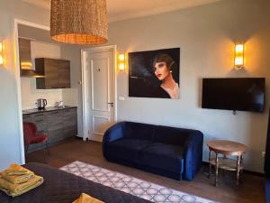 a living room with a blue couch and a painting on the wall at Hotel Stadsherberg Sneek in Sneek