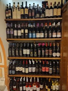 Ospitalità Baffone casa vacanze في Mercato: رف مملوء بالكثير من زجاجات النبيذ