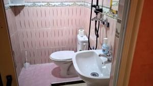 a bathroom with a white toilet and a sink at Auberge Cascade Imilchil in Imilchil