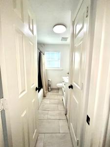 einen Flur eines Badezimmers mit WC und Waschbecken in der Unterkunft Cozy and Convenient! in Port Arthur