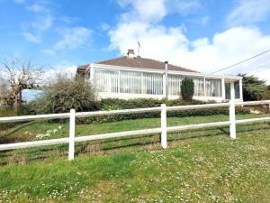 a white fence in front of a house at Gîte du Hérisson in Le Val-David +5 photos