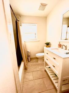 ein Bad mit einem Waschbecken, einem WC und einem Fenster in der Unterkunft Cozy and Convenient! in Port Arthur
