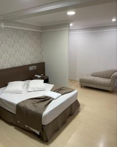 a bedroom with a large bed and a chair at Abbas Hotel in Uberlândia