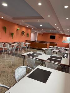 Abbas Hotel في أبرلانديا: غرفة فارغة فيها طاولات وكراسي