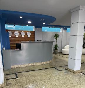a lobby with a counter with clocks on the wall at Abbas Hotel in Uberlândia