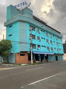 a blue building with a hotel sign on top of it at Abbas Hotel in Uberlândia