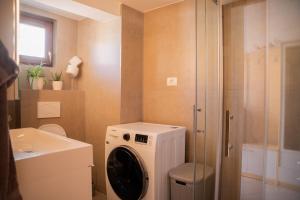 een badkamer met een wasmachine en een wastafel bij Apartment Uno in Koper