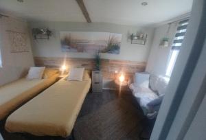 a small room with two beds and a couch at Chalet Zeewind in Oostkapelle
