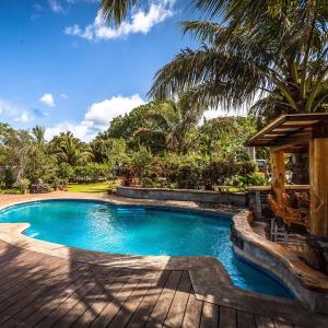 una piscina en un complejo con palmeras en Hotel Chez Maria Goretti, en Hanga Roa