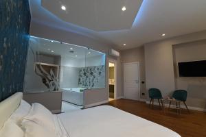 1 dormitorio con 1 cama grande y TV en Slopes Suites and SPA, en Boscotrecase