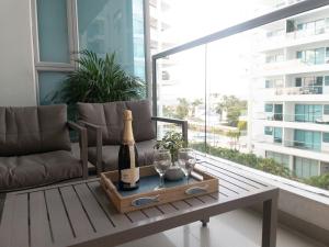 una habitación con una mesa con una botella de champán y copas en Luxury Morros Seaway Cartagena, en Cartagena de Indias