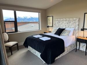 a bedroom with a bed and a large window at Peaceful Retreat - Hawea Flat in Hawea Flat