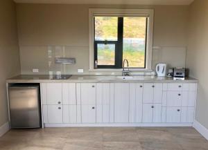 een keuken met een wastafel en een raam bij Peaceful Retreat - Hawea Flat in Hawea Flat