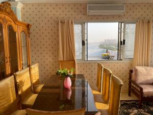 uma sala de jantar com uma mesa e cadeiras e uma janela em Nile and island no Cairo