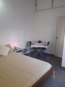 1 dormitorio con cama, mesa y mesa en Mi lugar, en Buenos Aires 3 fotos más