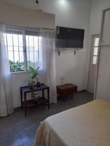 Un dormitorio con una cama y un televisor de pantalla plana. en Mi lugar, en Buenos Aires