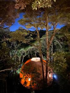 an orange tent under a tree at night at Way To Heaven Glamping in Monteverde Costa Rica
