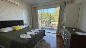 a bedroom with a bed and a large window at Residencial Dona Odila - Excelente Localização in Foz do Iguaçu