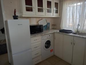 eine Küche mit einem weißen Kühlschrank und einer Waschmaschine in der Unterkunft Modern Bungalow with private pool and patio in Old Yundum