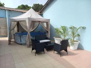Zelt mit Stühlen und einem Tisch auf der Terrasse in der Unterkunft Modern Bungalow with private pool and patio in Old Yundum