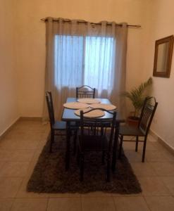 a dining room with a table and chairs and a window at Modern Bungalow with private pool and patio in Old Yundum