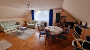 a living room with a table and a couch at Beáta Apartman in Gyula