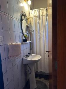 y baño con lavabo, espejo y ducha. en Casa de las Chacras 2 en San Carlos de Bariloche