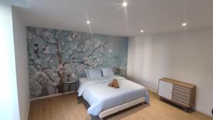 - une chambre avec un lit blanc et une fresque murale sur les arbres dans l'établissement Résidence du Palais, à Nevers