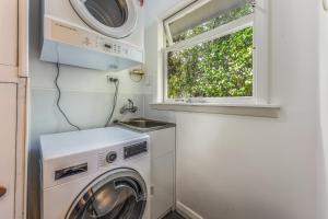 a laundry room with a washing machine and a window at Lush Oasis - Blenheim Holiday Home in Blenheim