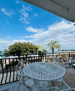 - une table et des chaises blanches sur un balcon donnant sur l'océan dans l'établissement Case Vacanze di Isabella Stoia, à Giardini Naxos