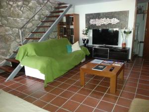 sala de estar con sofá verde y TV en Green House, en Oporto