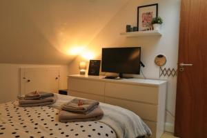 una camera con letto e televisore su un comò di Top Floor Apartment in Islington a Londra