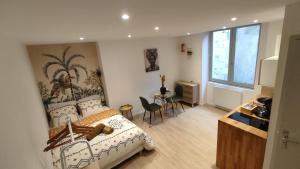 a bedroom with a bed and a table with chairs at Résidence du Palais in Nevers