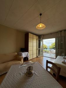 - un salon avec une table et un canapé dans l'établissement Case Vacanze di Isabella Stoia, à Giardini Naxos